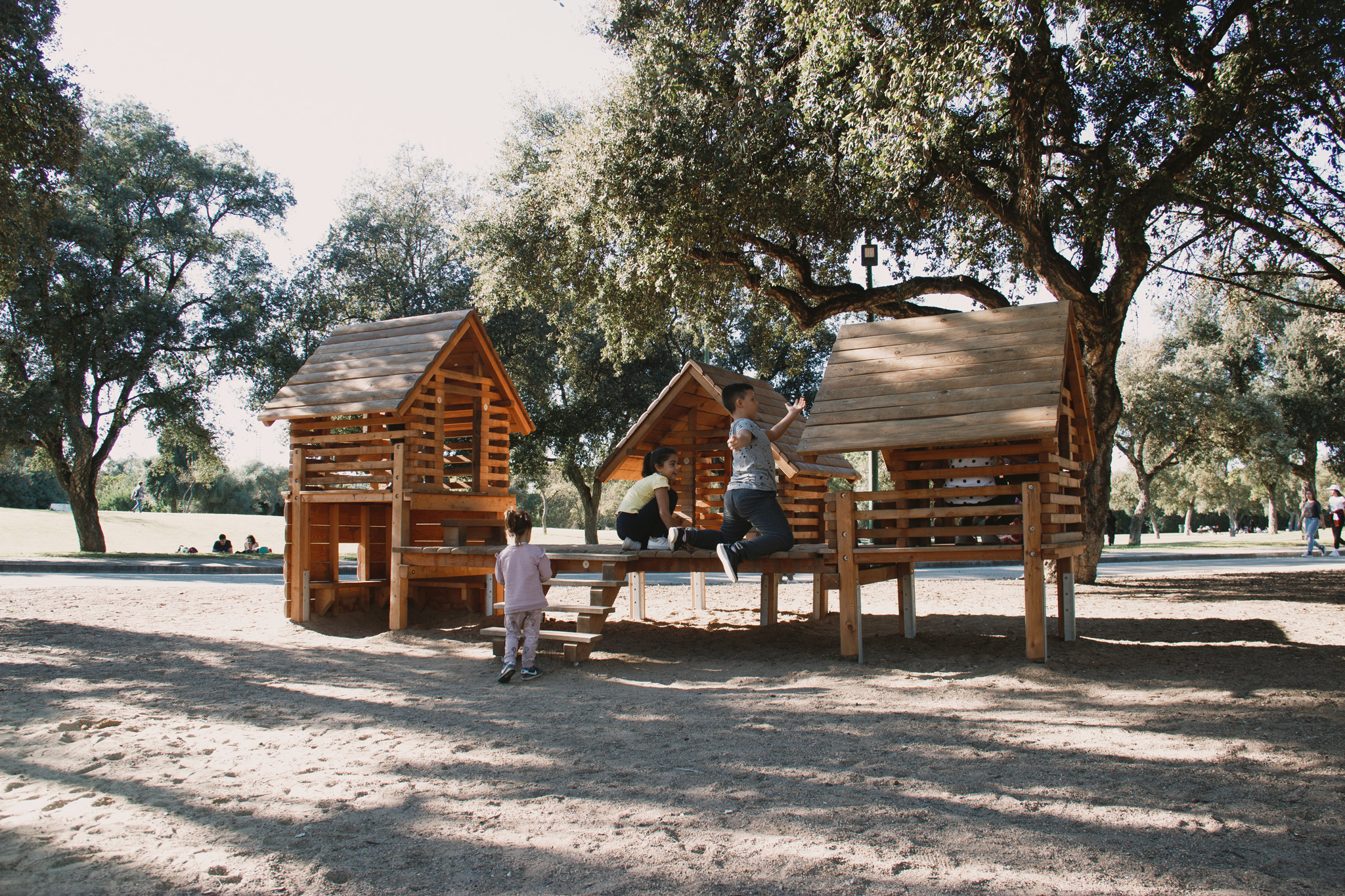 Unternehmen - Pfahldorfhäuser auf einem schattigen Waldspielplatz in Spanien.  - Richter Spielgeräte GmbH